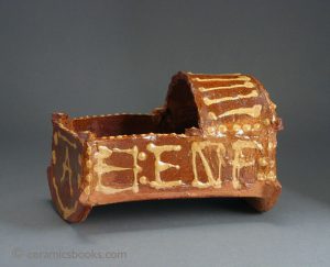 Earthenware cradle with slip decoration of part of alphabet. Possibly Dutch? C18th or C19th. AP/473