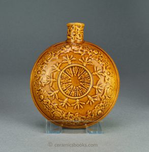 Small round treacleware (Rockingham glazed) spirit flask with moulded leaves and flowers. c.1840-1860. AP/1119.
