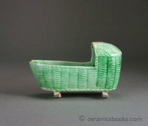 Creamware miniature cradle with translucent green glaze. Basket moulding. 107mm Long. c.1800-1820. AP/329.
