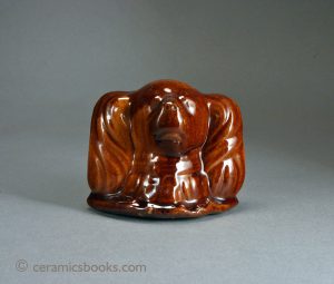 Treacleware dog's head moneybox. Often attributed to Scotland but made widely in Staffordshire. Rated D [Huebner] but A-B more realistic. 85mm High. c.1860-1890. AP/381.