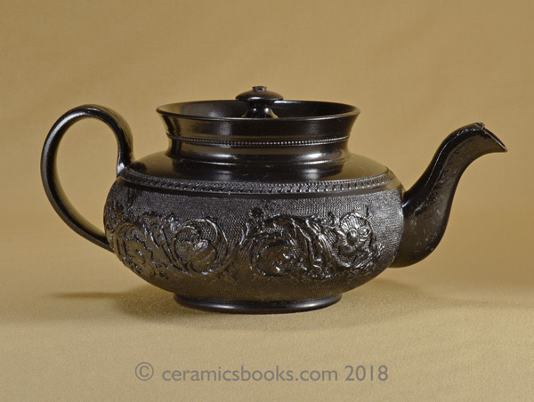 Small low-round black basalt teapot with floral sprig frieze on gauze background, marked CYPLES. Reverse. AP/1005
