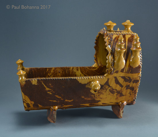 Agateware cradle with slip inscription “M J + R 1856”. Attributed to Woodman House Pottery, Halifax. Obverse. P/1072.
