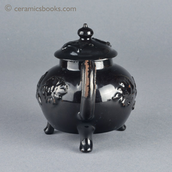 Shining Black 'Jackfield' type teapot on 3 feet with applied vine leaf and flower sprigs c.1755-1765. Back. AP/1240.