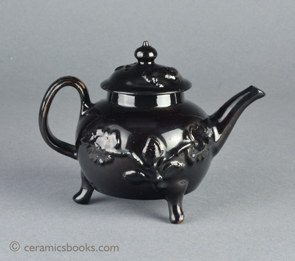 Shining Black 'Jackfield' type teapot on 3 feet with applied vine leaf and flower sprigs c.1755-1765. Reverse. AP/1240.