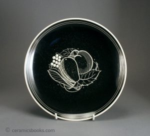 Unusual Susie Cooper 'sgraffito' plate with fruit design against black slip. c.1932-1960. AP/590.