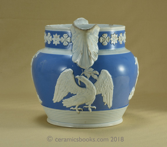 Pearlware blue ground jug with white clay sprigs including a greyhound, an eagle and a stag. Front. AP/722.