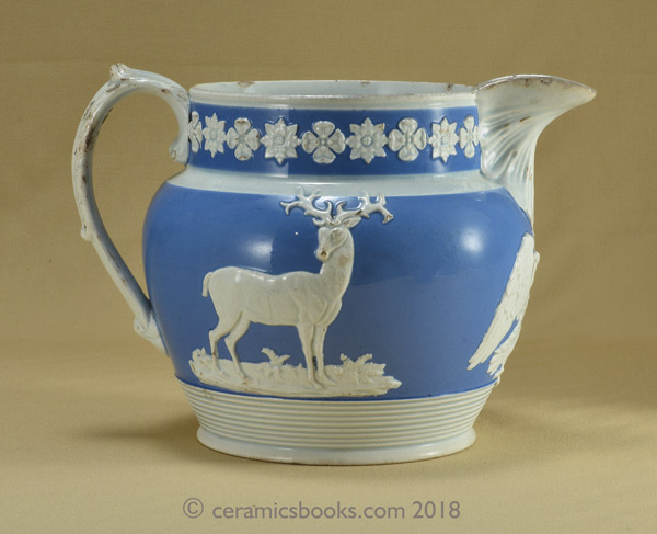 Pearlware blue ground jug with white clay sprigs including a greyhound, an eagle and a stag. Reverse. AP/722.
