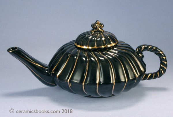 Jackfield glazed low-round teapot, spiral form with gold highlights. Obverse. AP/799