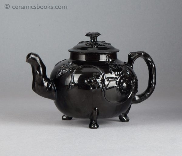 Jackfield type black-glazed teapot with grapevine and flower sprigs. Obverse, angle.