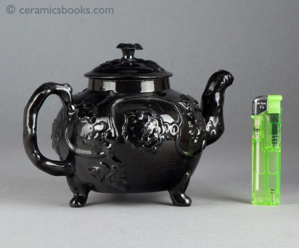 Jackfield type black-glazed teapot with grapevine and flower sprigs. Reverse with lighter.