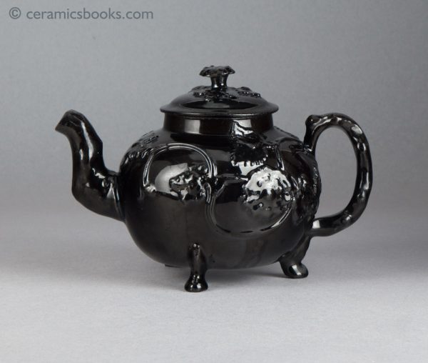 Jackfield type black-glazed teapot with grapevine and flower sprigs. Obverse.