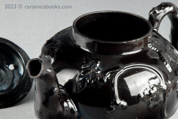 Jackfield type black-glazed teapot with grapevine and flower sprigs. Close rim.