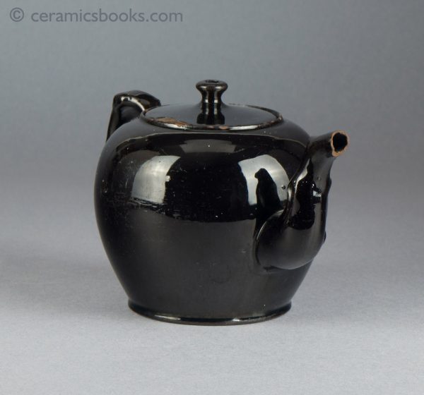'Jackfield' type black-glazed globular teapot with crabstock handle and spout. c.1765-1780. Front.
