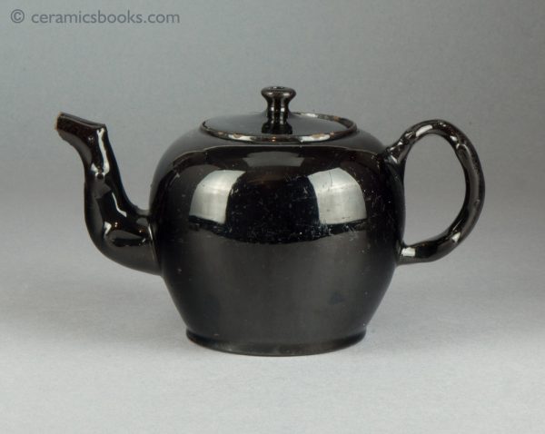 'Jackfield' type black-glazed globular teapot with crabstock handle and spout. c.1765-1780. Obverse.