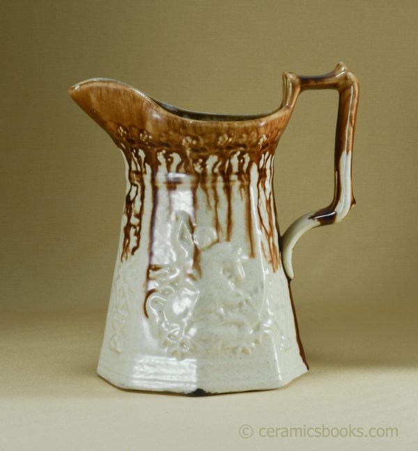 "Dipped" treacleware octagonal jug with moulded George and Dragon. AP/989. Obverse.