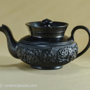 Black basalt teapot with arabesque scroll flower frieze. CYPLES. c.1820-1834. AP/1073. Obverse.