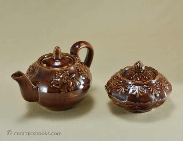Treacleware child size teapot with moulded flowers and similar sucrier. c.1860-1885. AP/195 and AP/624. Group.