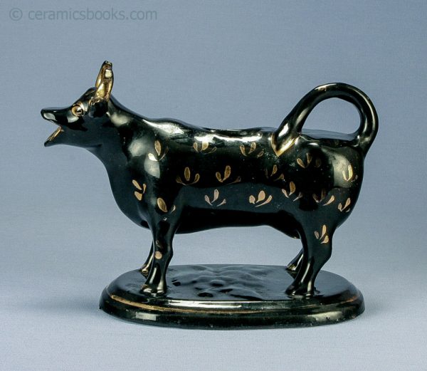 Jackfield type black glazed cow creamer. c.1860-1890. AP/616. Obverse.