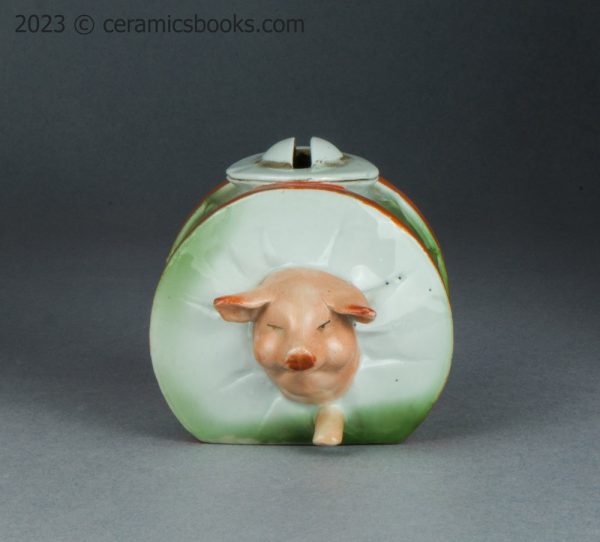 German porcelain moneybox pig running through drum. c.1910-1925. AP/1689. Front.