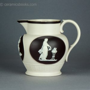 Felspathic stoneware jug with sprigs inside brown slip cartouches. Chetham & Woolley. c.1800-1810. AP/1643. Obverse.