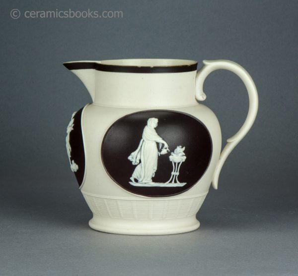 Felspathic stoneware jug with sprigs inside brown slip cartouches. Chetham & Woolley. c.1800-1810. AP/1643. Obverse.